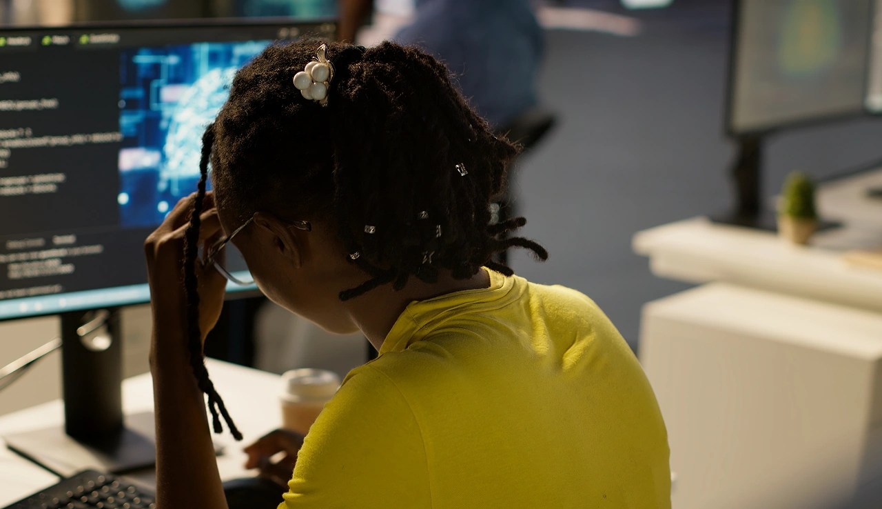 Person coding in yellow shirt